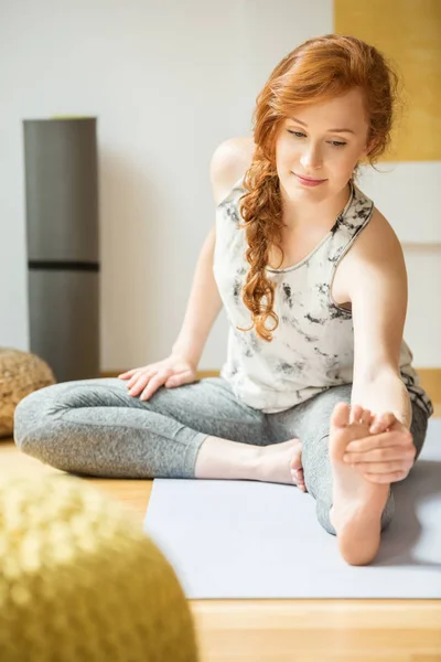 Frau dehnt sich während Yoga-Kurs — Stockfoto