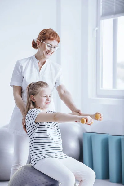 Sorrindo menina exercitando com halteres — Fotografia de Stock