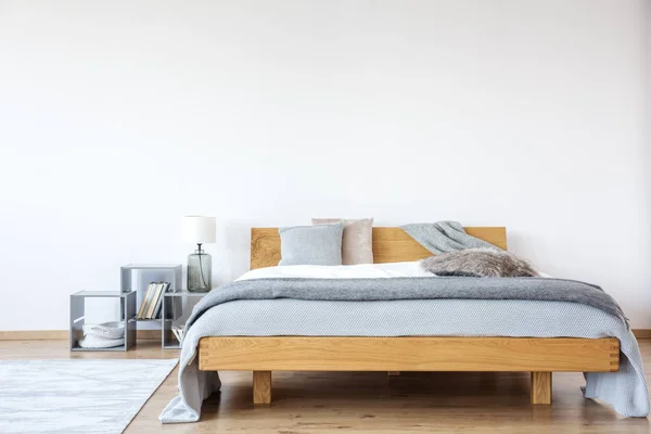 Деревянная двуспальная кровать в спальне — стоковое фото