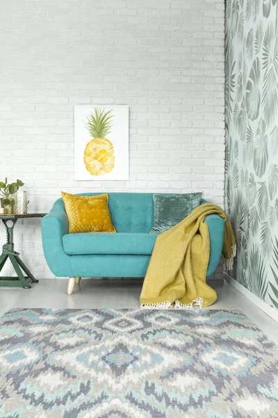 Желтое одеяло на бирюзовом диване — стоковое фото