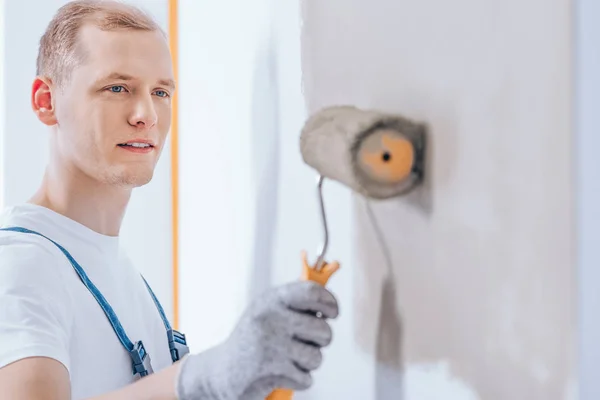 Arbetare med hjälp av paint roller — Stockfoto