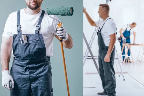 Especialista segurando um rolo de pintura — Fotografia de Stock