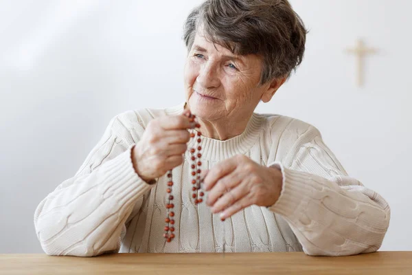 Улыбающаяся бабушка с четками — стоковое фото