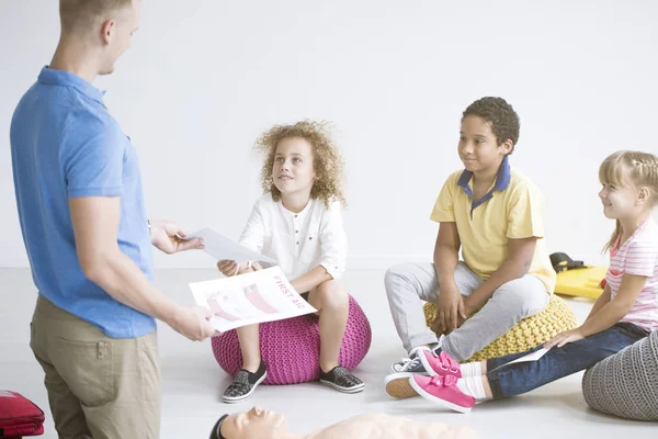 Médico dando panfletos a los niños — Foto de Stock