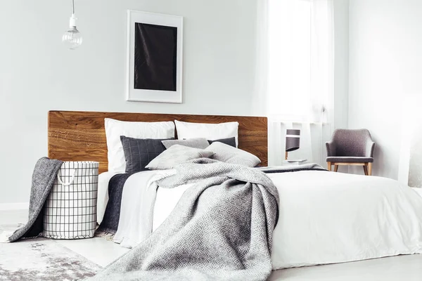 Zwarte poster boven houten bed — Stockfoto