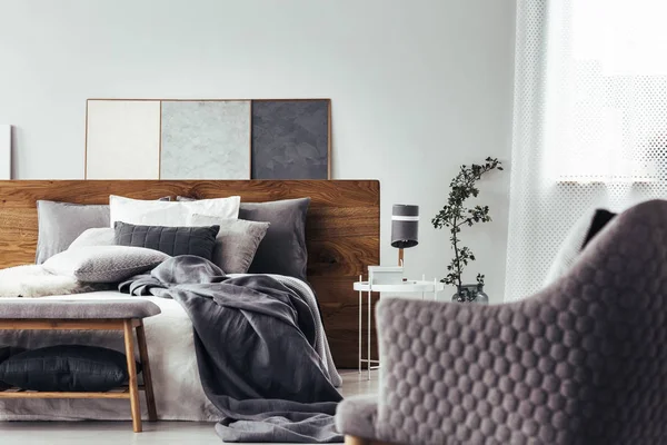 Gray armchair facing white bed — Stock Photo, Image