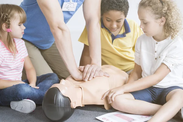 Paramedic showing children chest compressions Stock Picture