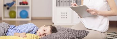 Autistic boy lying on pillows clipart