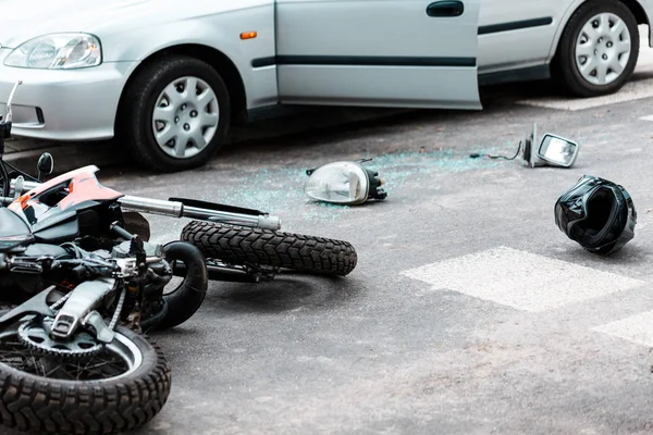 Legs of a person lying on the road after a motorcycle and car accident  #184689352 - Larastock