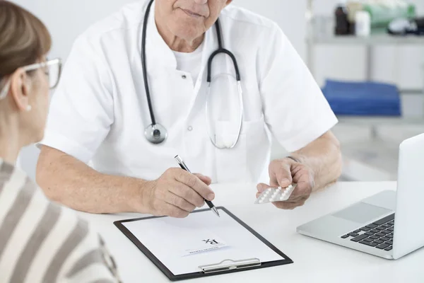 Médico segurando analgésicos — Fotografia de Stock