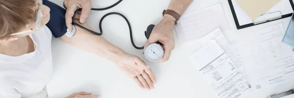 Médico midiendo la presión arterial del paciente —  Fotos de Stock