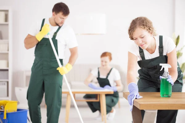 Vrouw met behulp van groene schoonmakende detergentia — Stockfoto