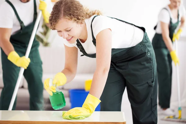 Junge Frau putzt den Tisch — Stockfoto