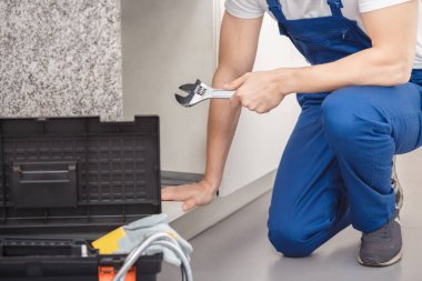 İngiliz anahtarı tutan el işleri ustası