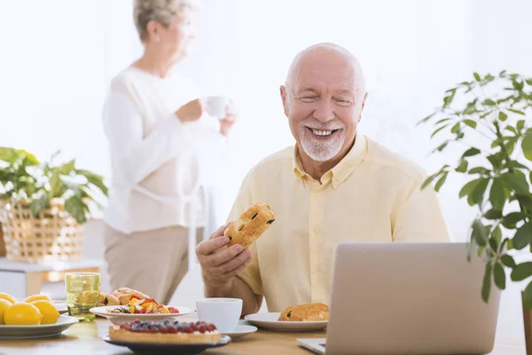 Homme âgé souriant utilisant un ordinateur portable — Photo