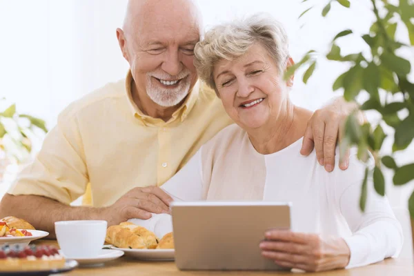 Casal sênior encantador usando tablet — Fotografia de Stock