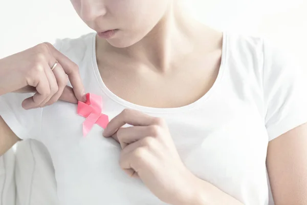 Mulher fixando uma fita rosa — Fotografia de Stock