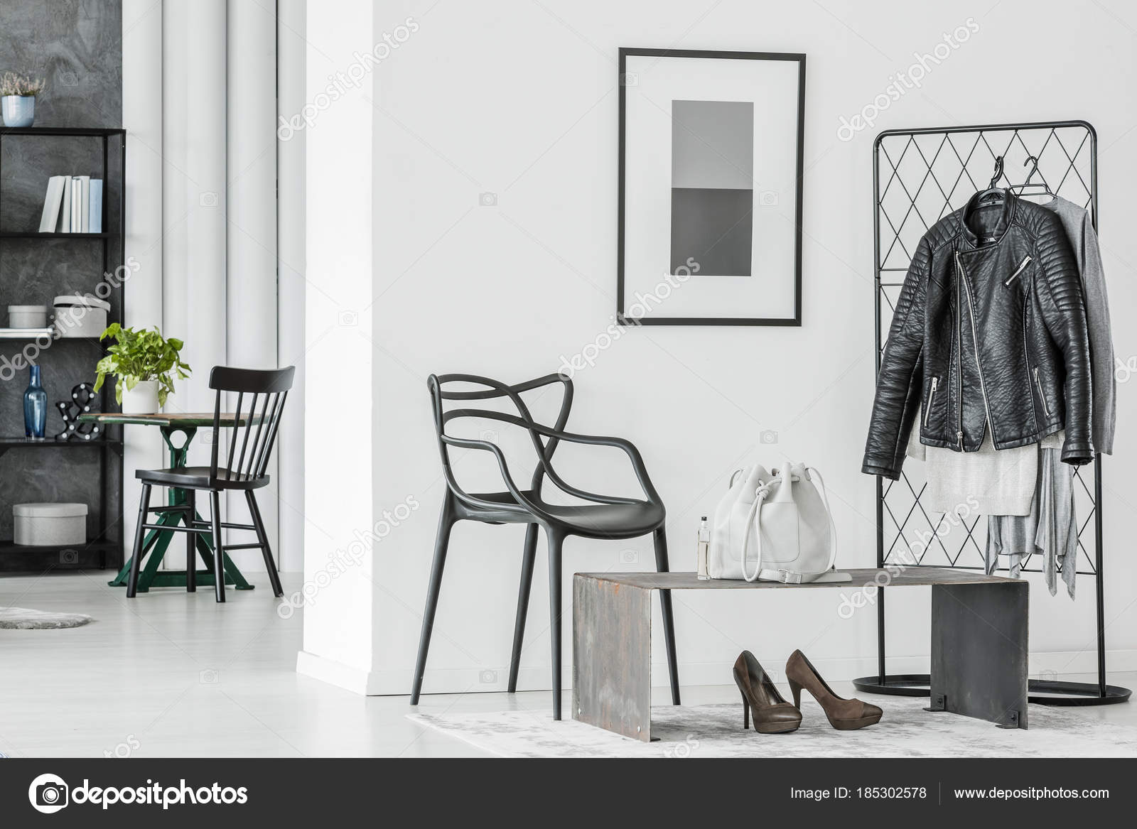 Cómoda silla negra con sillas blancas y flores en la habitación moderna