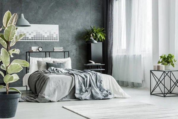 Кровать с серыми простынями — стоковое фото