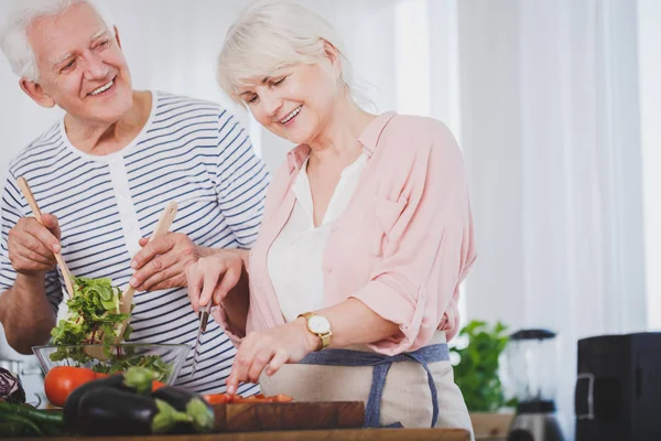 Glimlachende senior mensen voorbereiding salade — Stockfoto