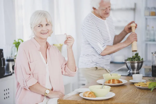 Sonriente mujer mayor bebiendo té — Foto de Stock