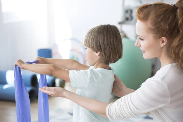 Sjukgymnast stödjande kid — Stockfoto