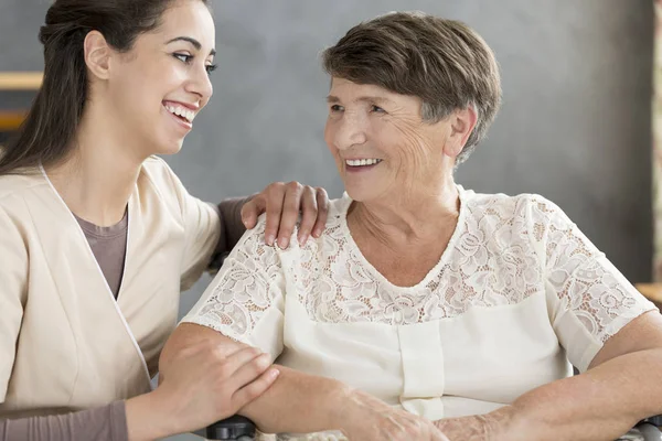 Voluntaria sonriente y anciana — Foto de Stock