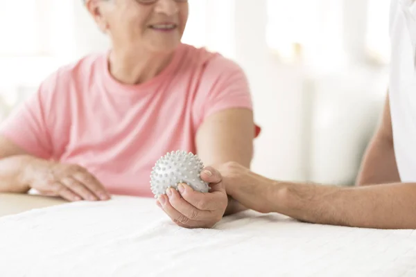 Elderly patient holding grey ball — Stock Photo, Image