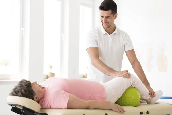 Fisioterapeuta que apoya a la mujer mayor — Foto de Stock