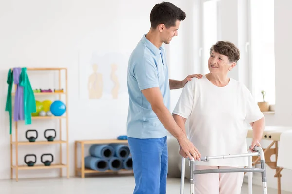 Elderly woman and caring physiotherapist — Stock Photo, Image