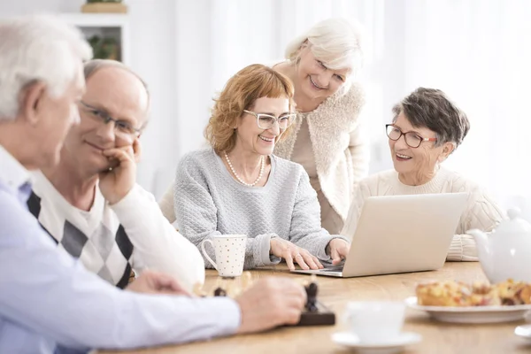 Grupp av seniorer som sitter vid bord — Stockfoto