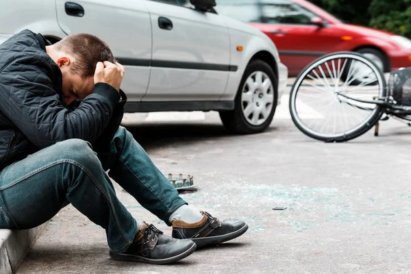 Man sitting on sidewalk — Stock Photo, Image