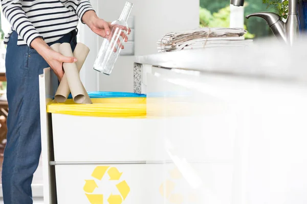 Домохозяйка бросает бумагу в мусорку — стоковое фото