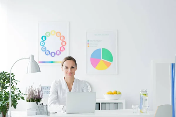 Nutricionista sorridente em escritório branco — Fotografia de Stock