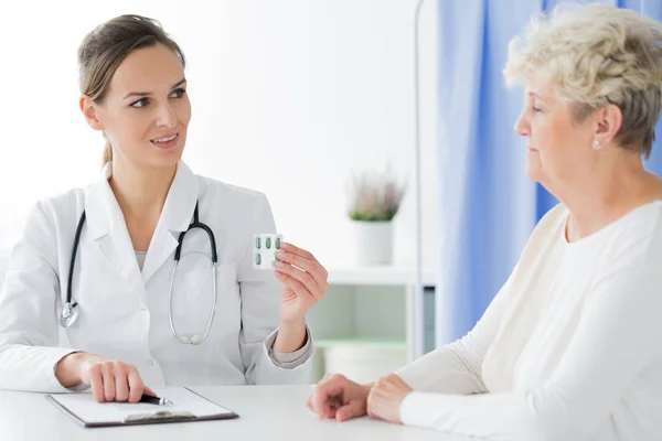 Arzt mit Stethoskop verabreicht Tabletten — Stockfoto