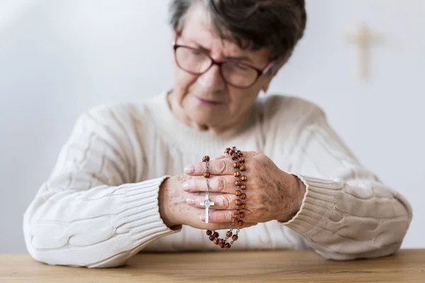 Contemplare donna anziana con rosario — Foto Stock
