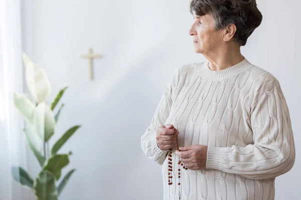 Религиозная бабушка молится в церкви — стоковое фото