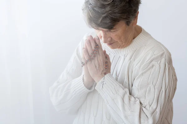 Religious senior person praying