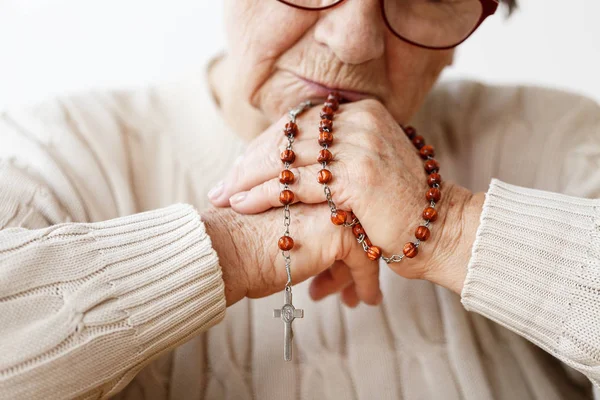 Mani di donna anziana con rosario — Foto Stock