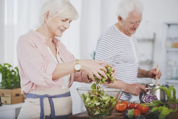 Ältere Frau wirft einen Salat — Stockfoto