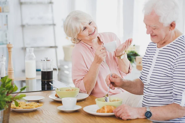 Двоє літніх людей розмовляють під час сніданку — стокове фото