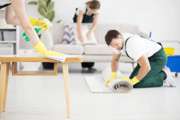 Man rolling carpet while cleaning — Stock Photo, Image