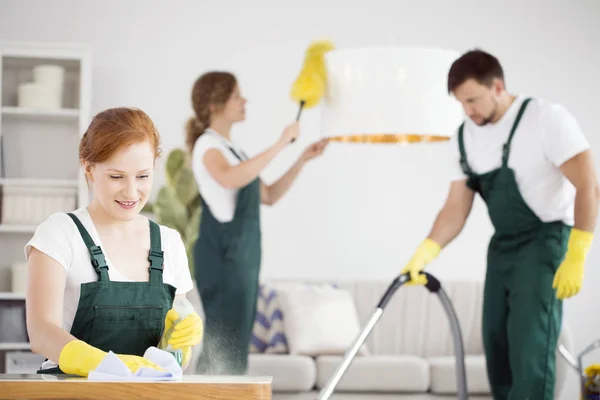 Mujer desempolvando y hombre aspirando —  Fotos de Stock