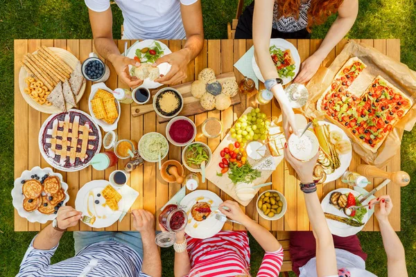 Amigos comendo panquecas e frutas — Fotografia de Stock