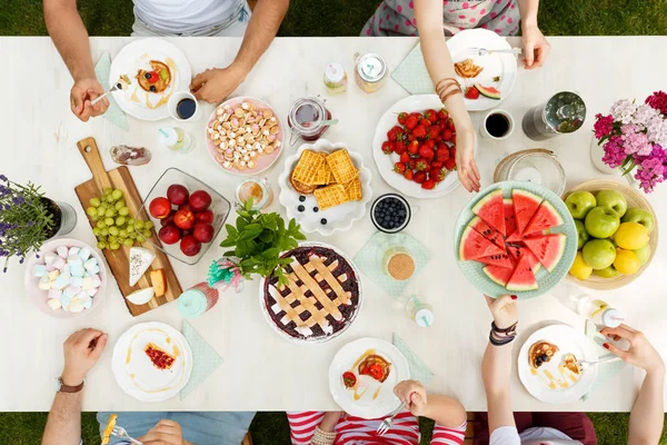 Personer som delar vattenmelon vid bord — Stockfoto