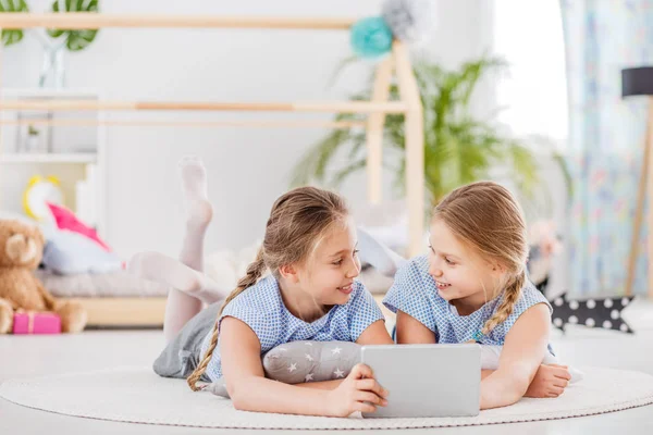 Chicas gemelas compartiendo una tableta — Foto de Stock