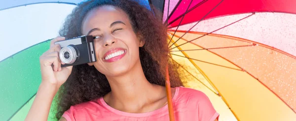 Kvinnan tar ett foto under färgglada paraply — Stockfoto