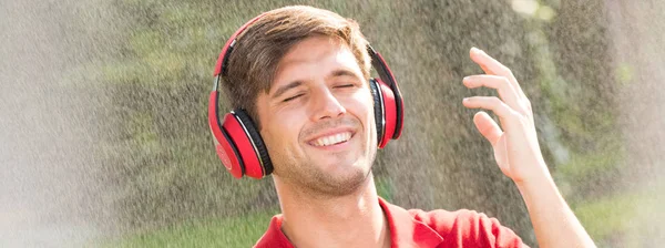 Homem ouvindo música durante a chuva — Fotografia de Stock