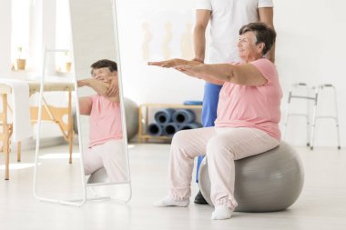 Senior exercising with physiotherapist clipart