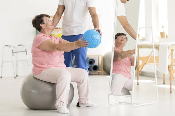 Mujer mayor en pelota de ejercicio — Foto de Stock